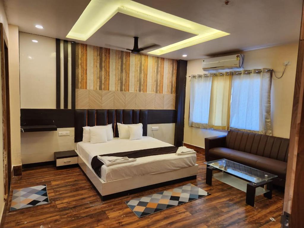 SiwānHotel Grand Patliputra的一间卧室配有一张床和一张沙发