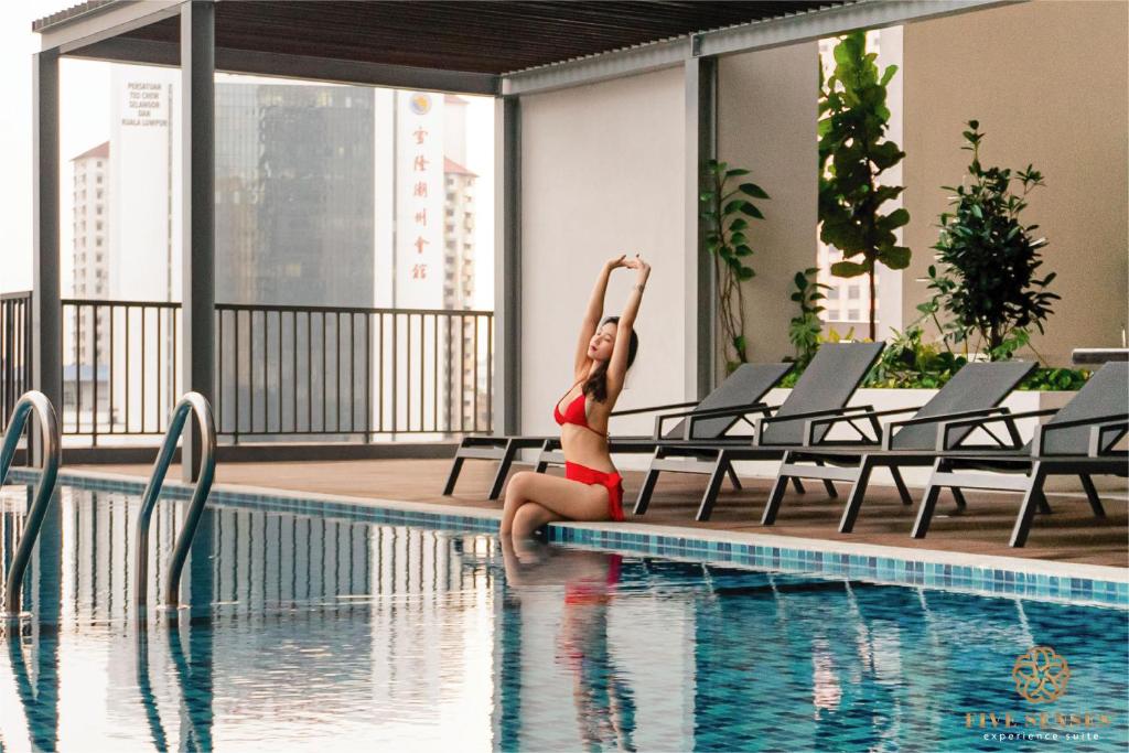 吉隆坡Chambers Kuala Lumpur by Five Senses的坐在游泳池旁的比基尼的女人