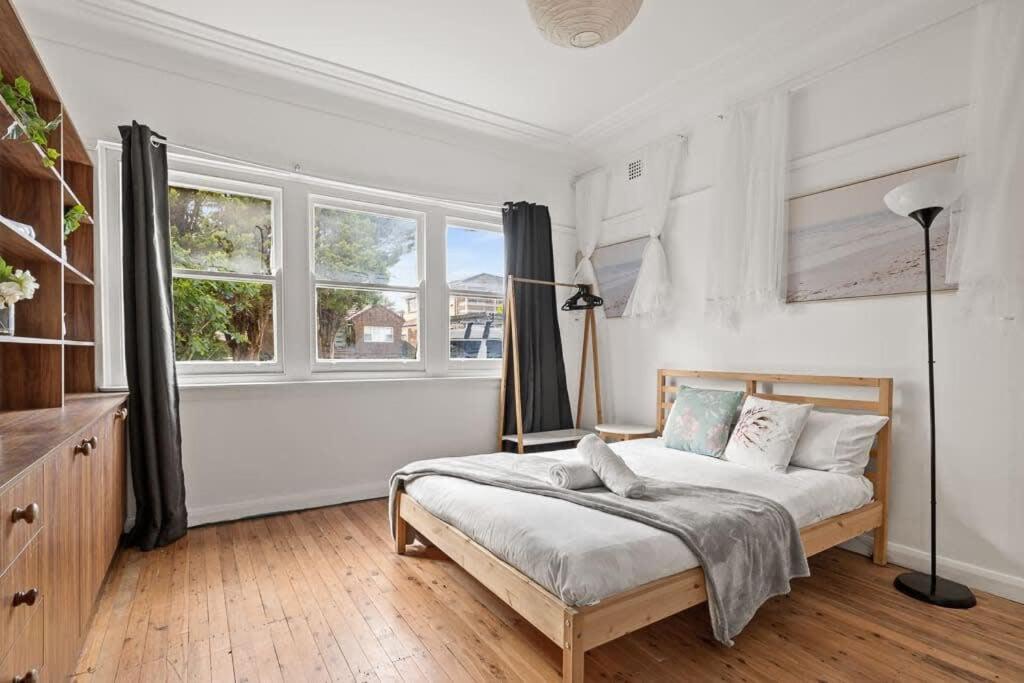 悉尼Double Room in Sans Souci SHARED HOUSE- 2的一间白色卧室,配有床和2个窗户
