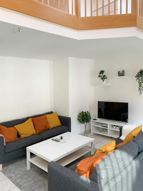 布里格Spacious and charming duplex in the centre of Brig的客厅配有两张沙发和一台电视机