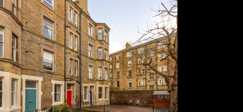 爱丁堡Palm Tree Apartment- Period Home with Cat的一排砖砌的建筑,有红色的门