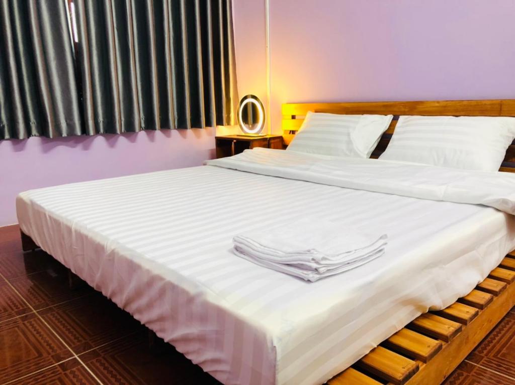 芹蒢HOSTEL ECO TOURISM CẦN GIỜ的一间卧室配有两张带白色床单和餐巾的床。