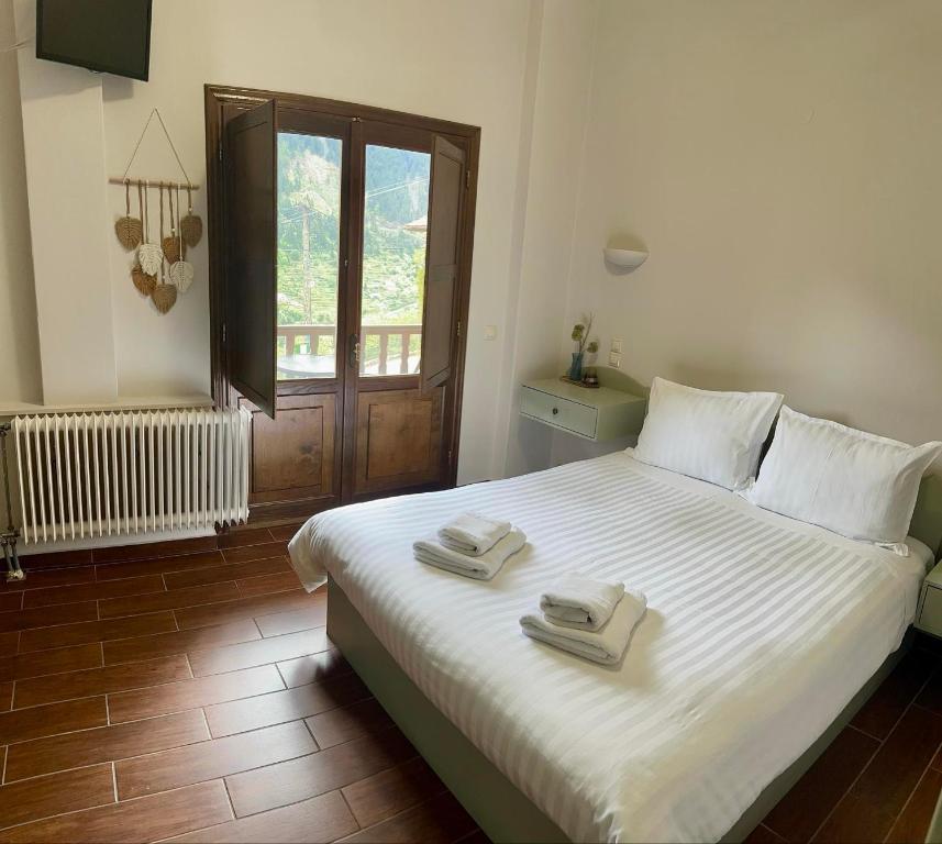 ProusósVia Ferrata Hotel的卧室配有带毛巾的大型白色床