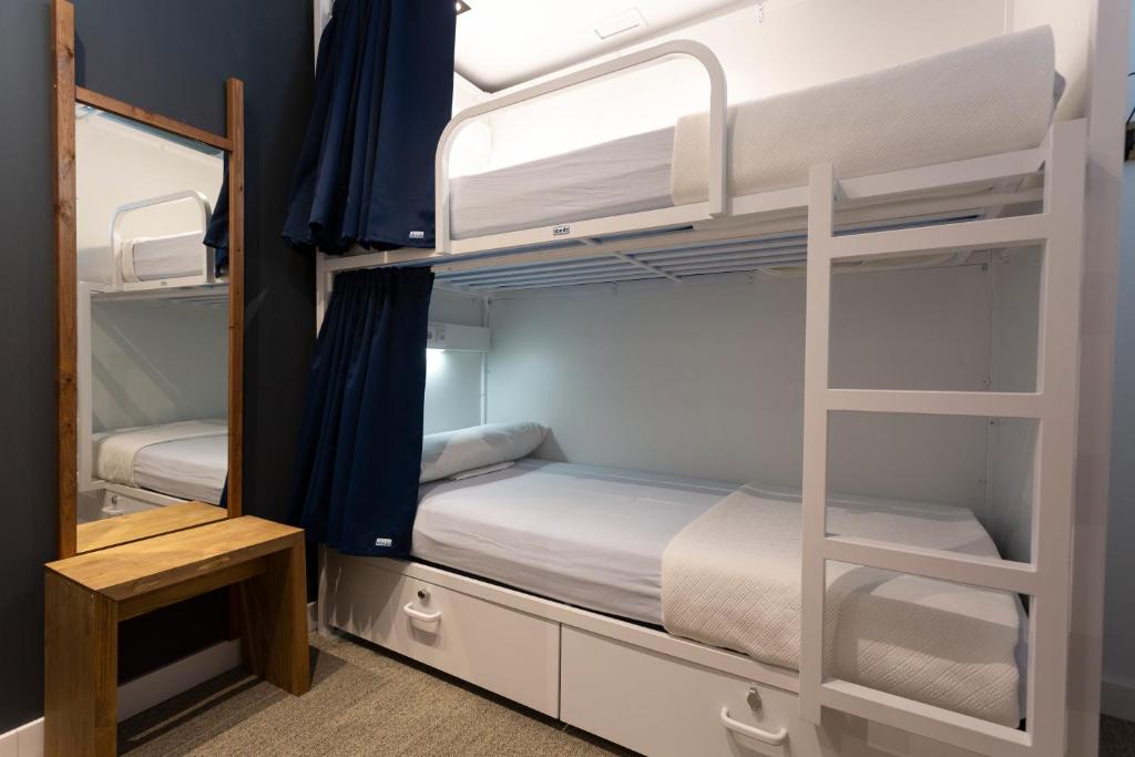 马拉加Malaga Stop Hostel AB的有两张双层床和一面镜子的房间