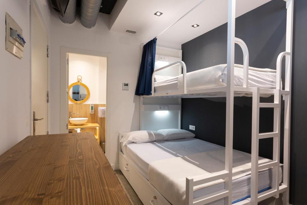 马拉加Malaga Stop Hostel AB的一间卧室，配有两张双层床和一张书桌