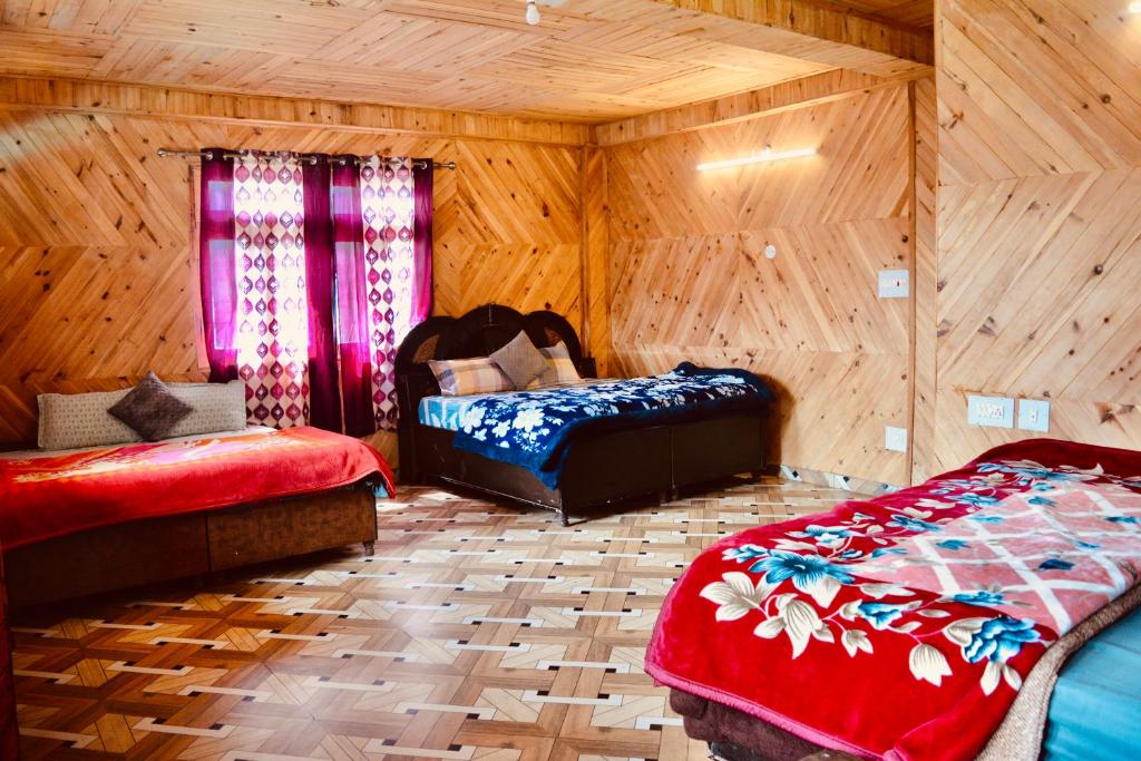 ToshPahadi Bliss Hostel ,Tosh的木制客房内的一间卧室配有两张床