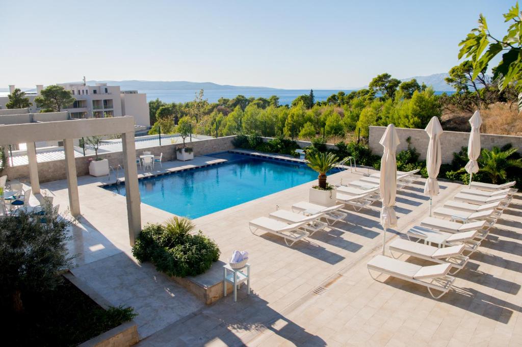马卡尔斯卡Poseidon Mobile Home Resort的一个带躺椅的游泳池和一个泳池景
