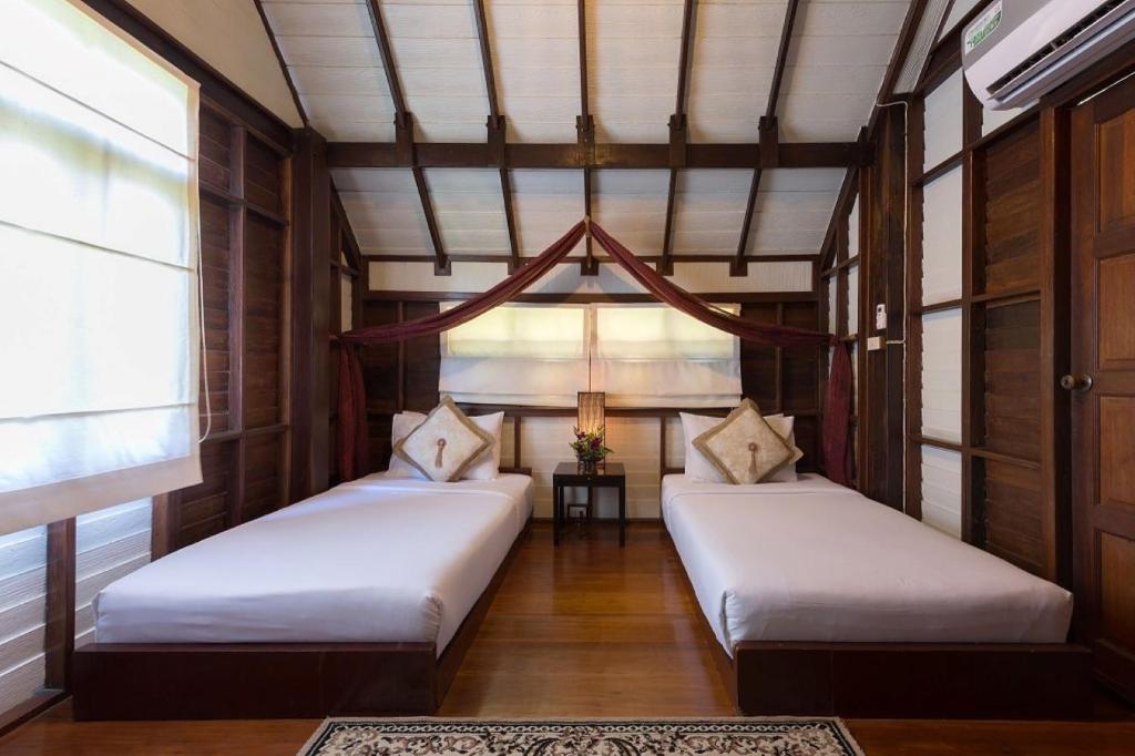 象岛象岛安妮卡酒店的配有木墙和天花板的客房设有两张床。