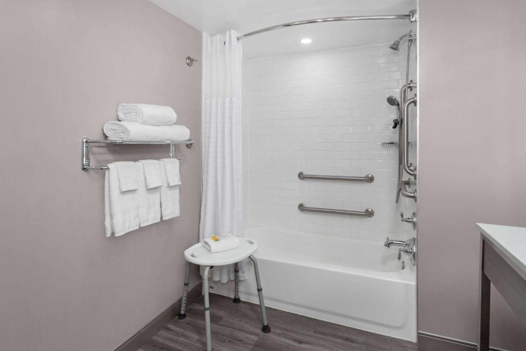 巴尔的摩Days-Inn by Wyndham Baltimore Northwest的带淋浴和盥洗盆的白色浴室
