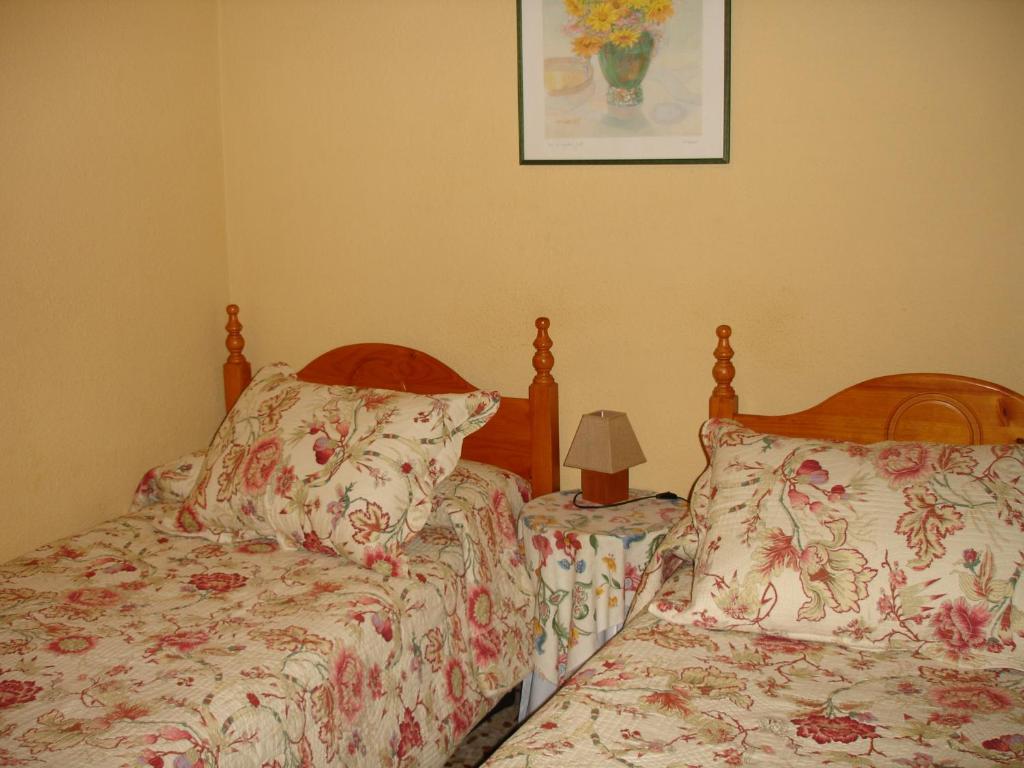马德里Hostal Puerta Bonita Vista Alegre的卧室配有两张床,墙上挂着一幅画