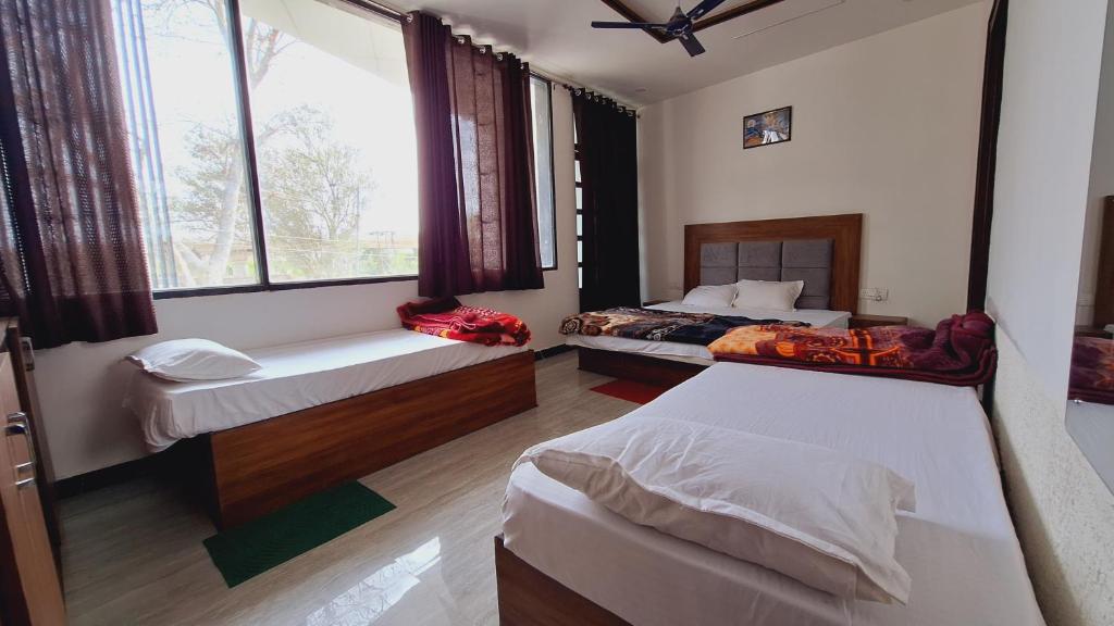 阿格拉Hotel MD Grand的一间卧室设有两张床和窗户。