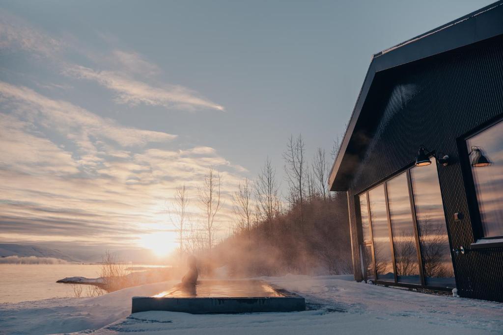 阿克雷里Svart Lodge的雪中,太阳在背后的建筑