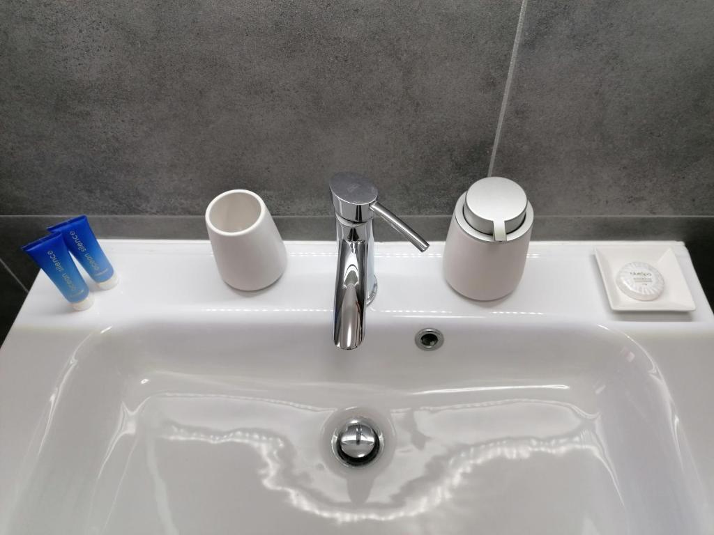 蒂沃利梅兰格罗旅馆的白色水槽,两杯,水龙头