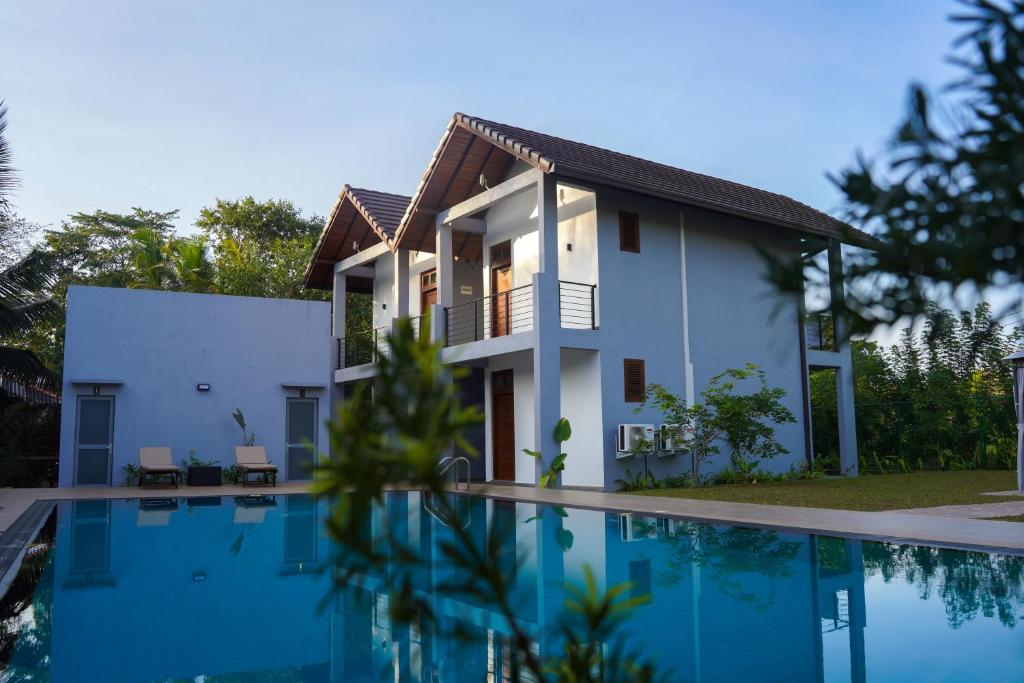 锡吉里亚Lion Gate Hotel Sigiriya的一座房子前面设有游泳池