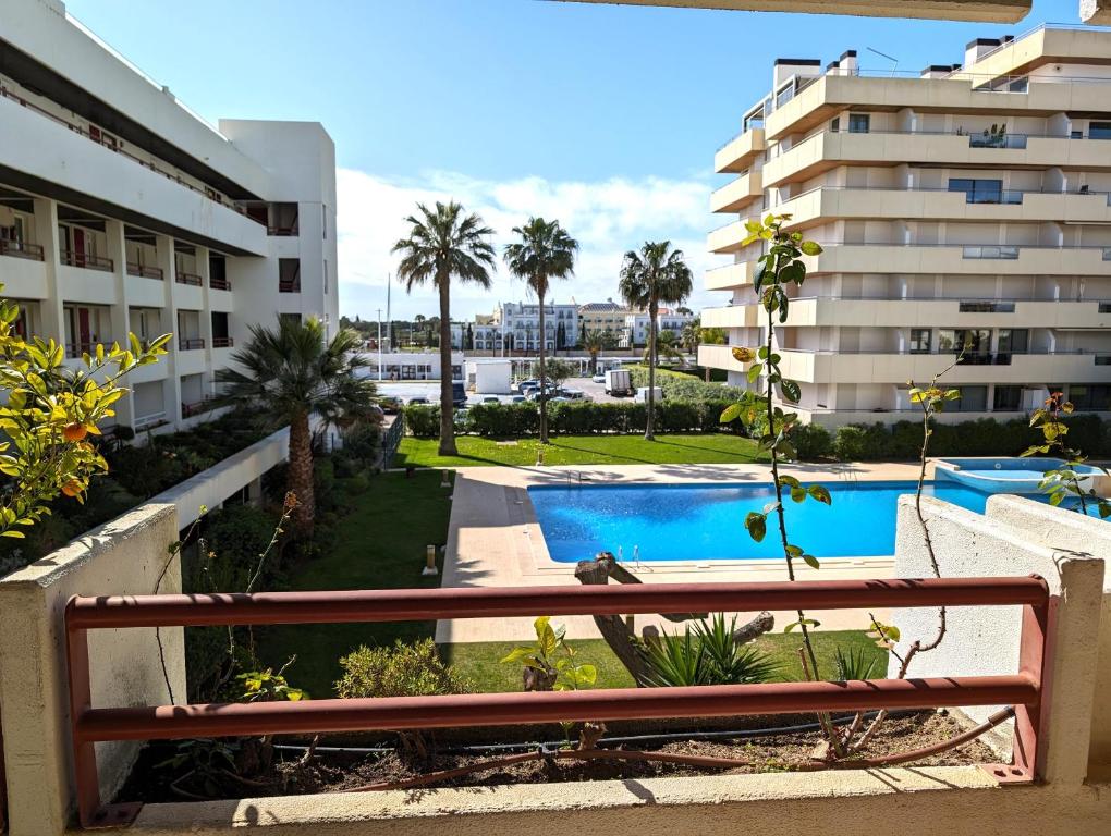 维拉摩拉Vilamoura House的从大楼的阳台上可欣赏到游泳池的景色