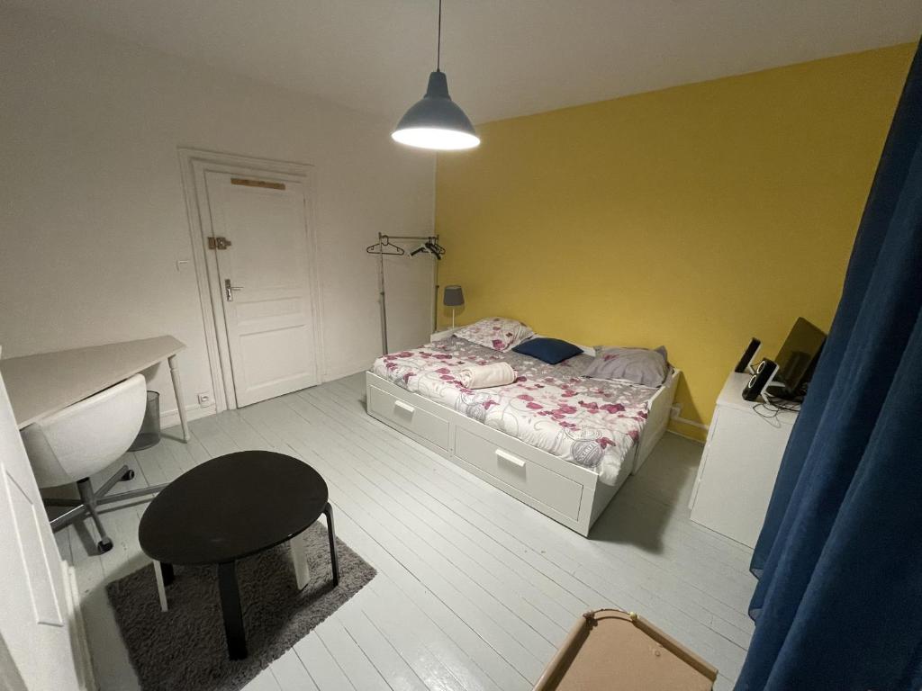 里摩日Bienvenu chez Zazou的一间卧室配有一张床、一张桌子和一把椅子