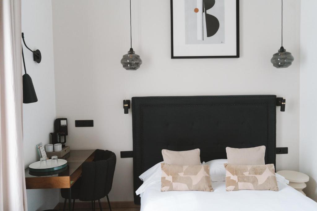 巴黎德斯贝奥克斯爱慈酒店的一间卧室配有一张黑色的床和一张书桌