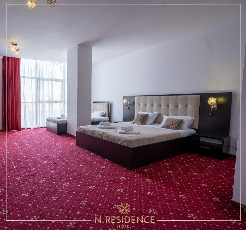 蒂米什瓦拉HOTEL N Residence的一间卧室配有一张大床和红地毯