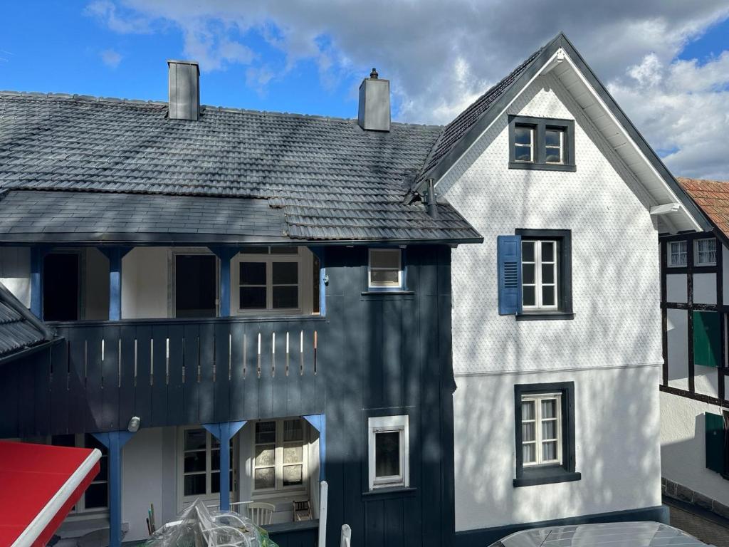 比赫莱尔塔尔Ferienhaus Bühlertal mit 3 Fewos的黑色屋顶的白色房子