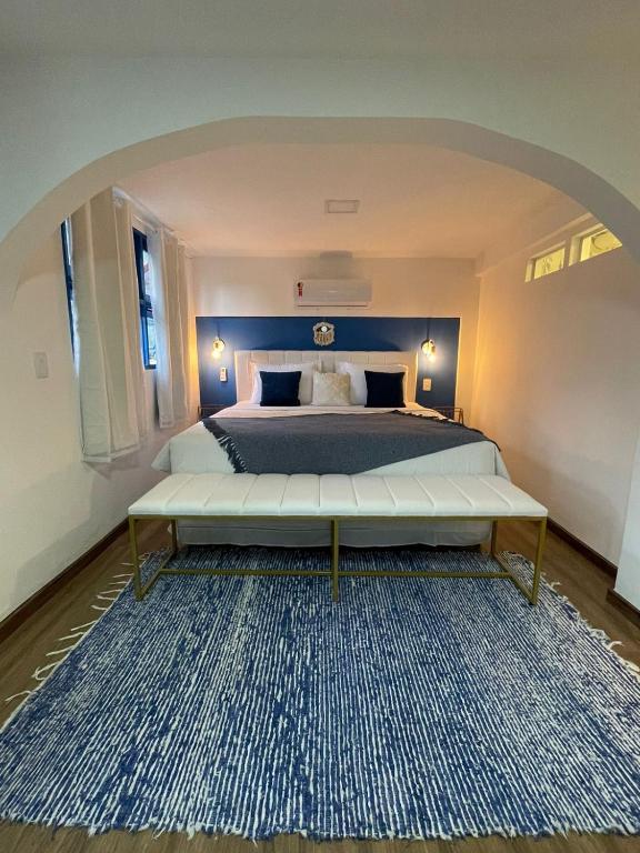 里约热内卢Cinque Terre Pousada & Bistrô的一间卧室配有一张大床和一张大地毯。