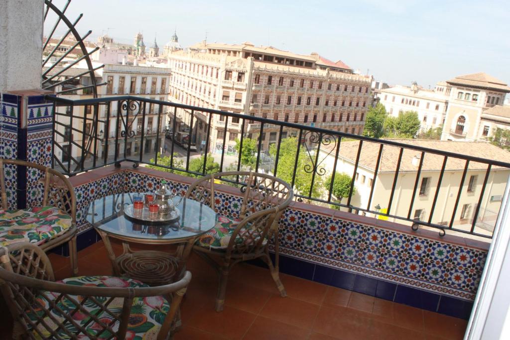 格拉纳达Apartamentos Vado - Cuesta de Alhacaba的设有一个配有桌椅并享有美景的阳台。