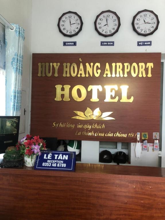 河内Huy Hoang Airport的香港机场酒店墙上挂有时钟的标志