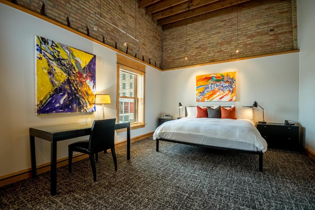 法戈唐纳森酒店的一间卧室配有一张床、一张书桌和绘画作品