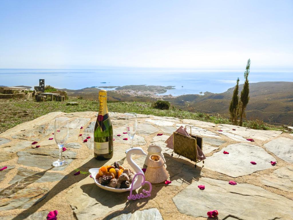 卡达克斯El paraíso de Cadaqués IMMO365的一张桌子,上面放着一瓶葡萄酒和一碗水果