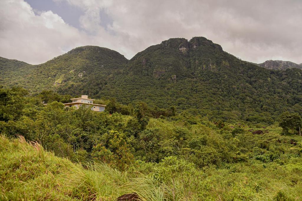 KalawanaThumpers Cottage的山丘上以山为背景的房子
