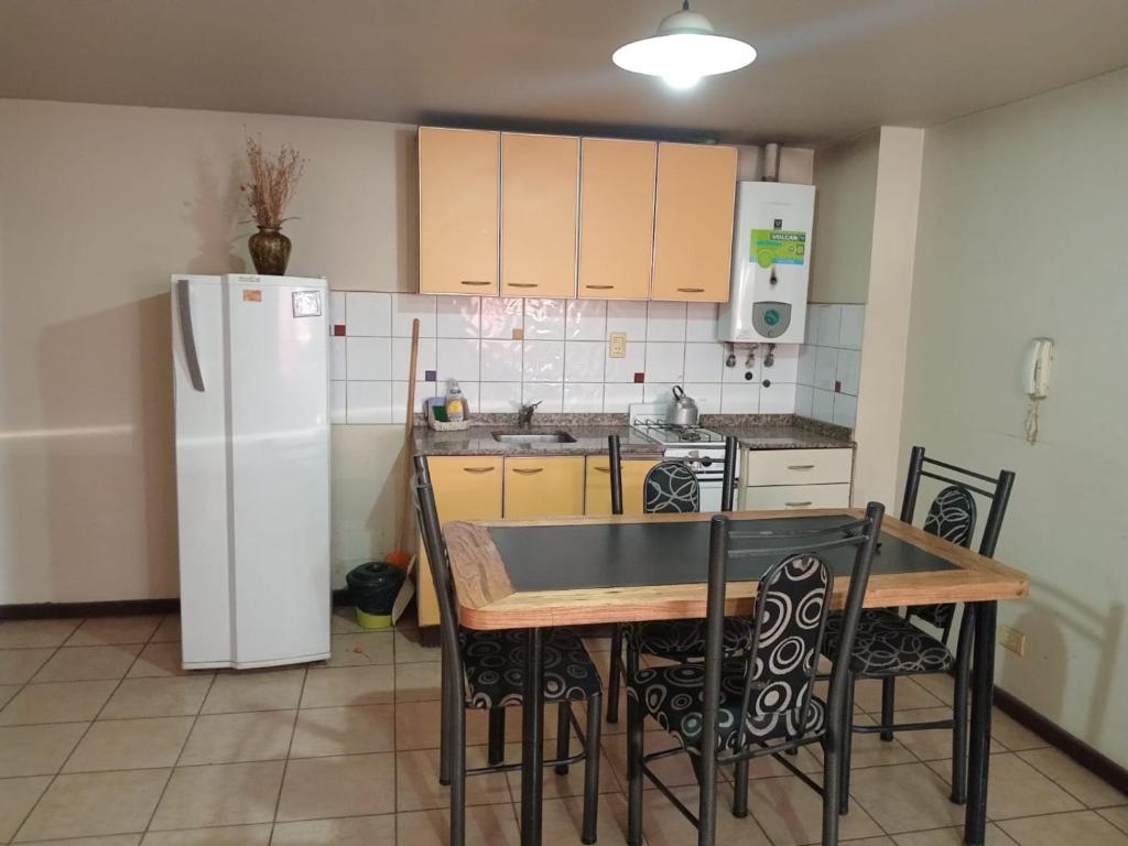 门多萨Departamentos Romano的厨房配有桌子和白色冰箱。