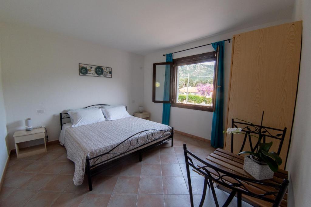 普拉Casa Martina的一间卧室设有一张床、一个窗口和一把椅子