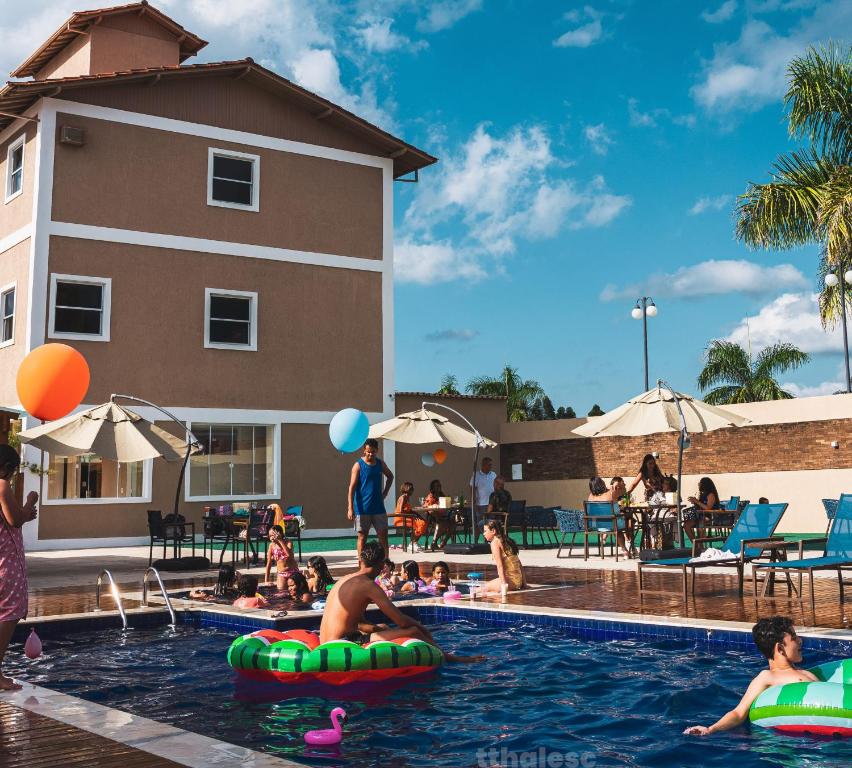迪亚曼蒂纳Hotel Estilo de Minas的一群人在度假村的游泳池里