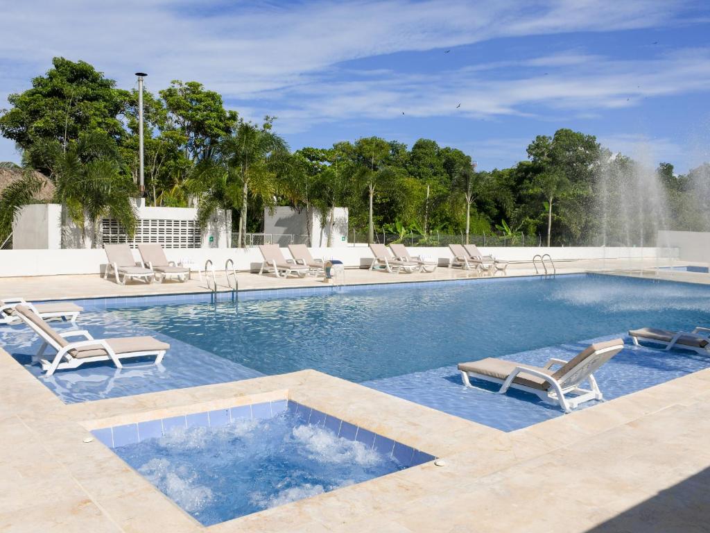 科韦尼亚斯Ciela Hotel & Beach Club的一个带躺椅的游泳池和一个喷泉