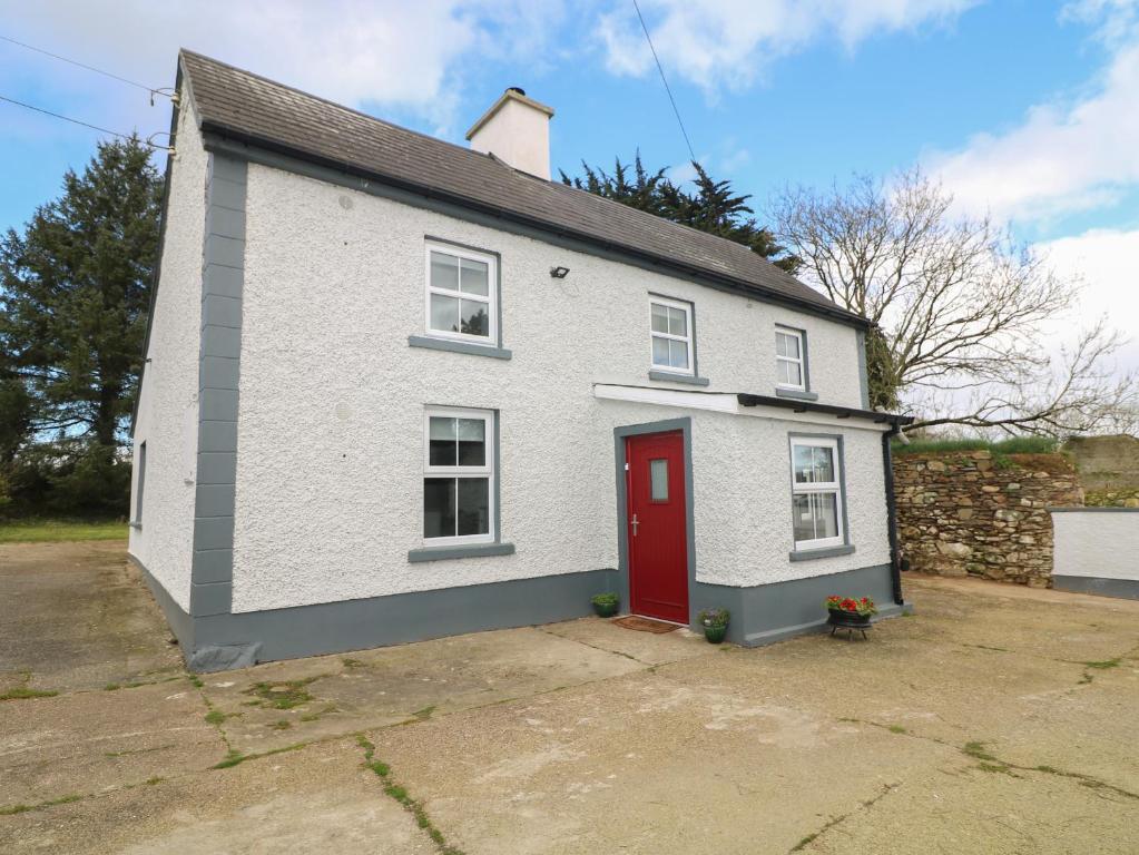 Curragh Cottage的一间红色门的白色房子
