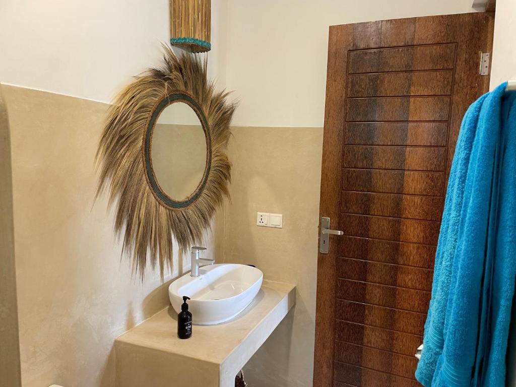 布韦朱Sand Beach Boutique Hotel的浴室设有水槽和墙上的镜子