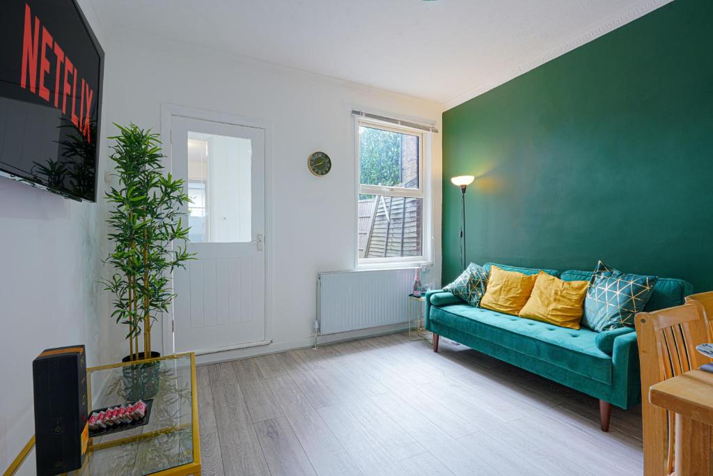 卢顿Modern Freshly Refurbed Home Luton的客厅设有蓝色的沙发和窗户。