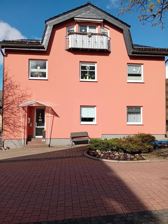 奥伯霍夫豪斯希泽布格公寓的粉红色的房子设有阳台和长凳