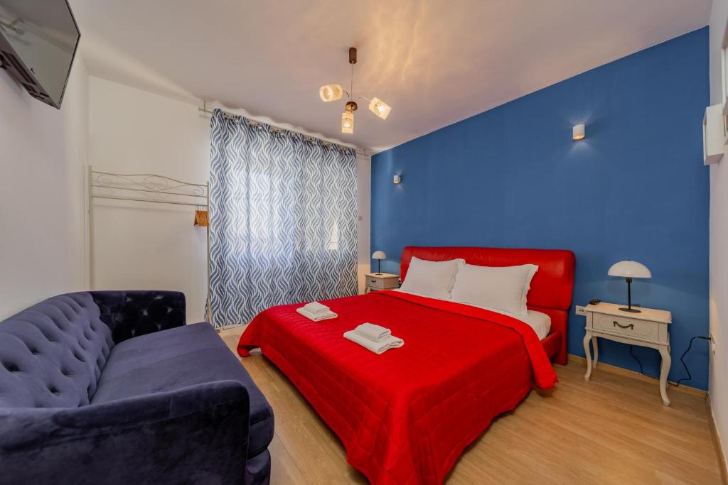 特罗吉尔Villa Croatia Trogir, Center, 4 rooms, parking, jacuzzi, free beach and pool 15 min的一间卧室设有红色的床和蓝色的墙壁