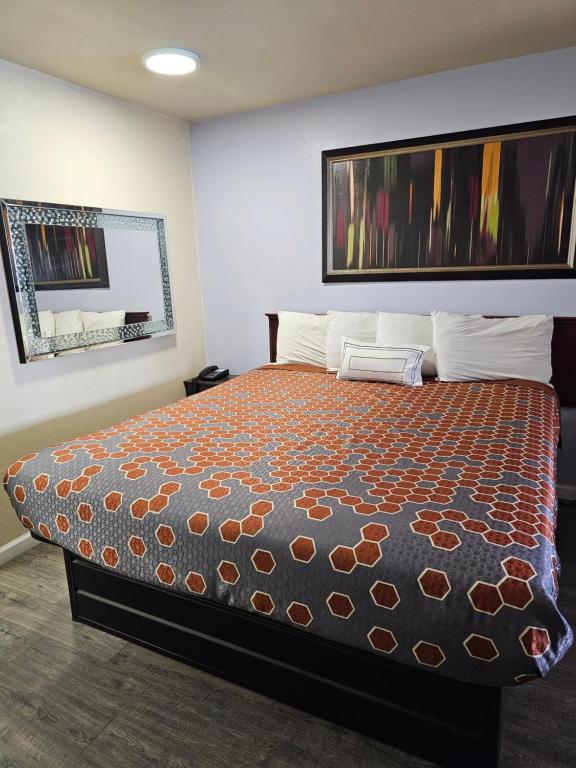 CalexicoCalifornia Suites Motel的一间卧室配有一张带橙色床罩的大床