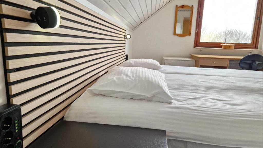 锡姆里斯港Vindsvåning i Simrishamn的卧室配有白色床和条纹墙