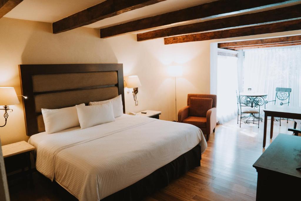 圣克里斯托瓦尔-德拉斯卡萨斯梅赛德斯圣克里斯托瓦尔别墅酒店的一间卧室配有一张床、一张桌子和一把椅子