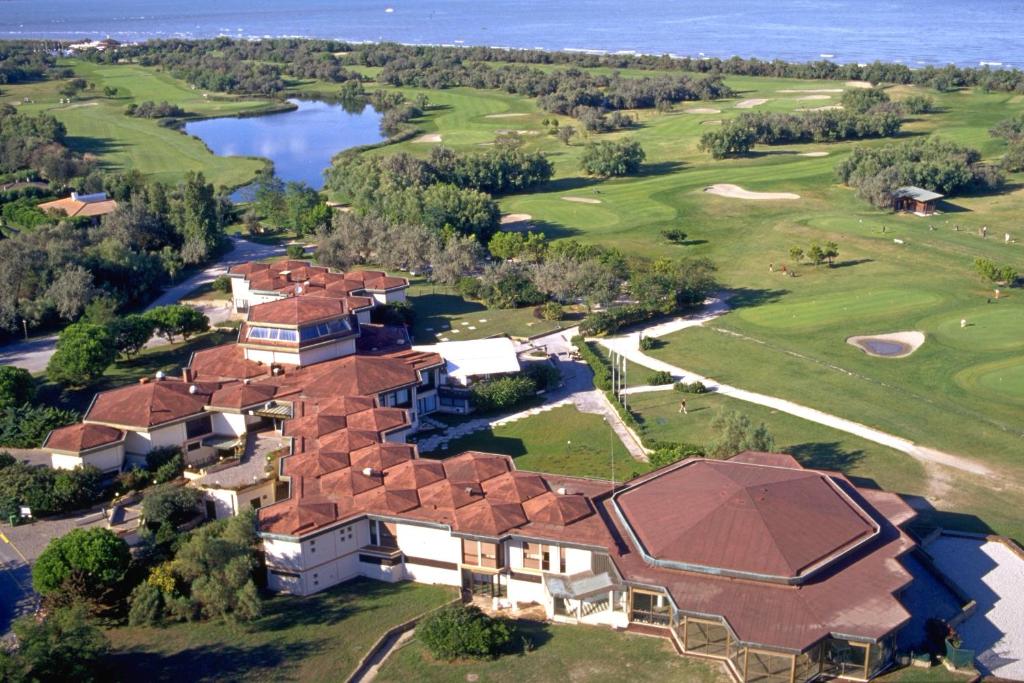 伊索拉阿尔巴勒拉Isola di Albarella Golf Hotel的享有带高尔夫球场的房屋的空中景致
