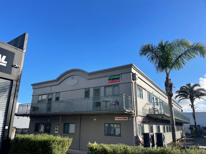 奥克兰Conway Motel Manukau的前面有棕榈树的建筑