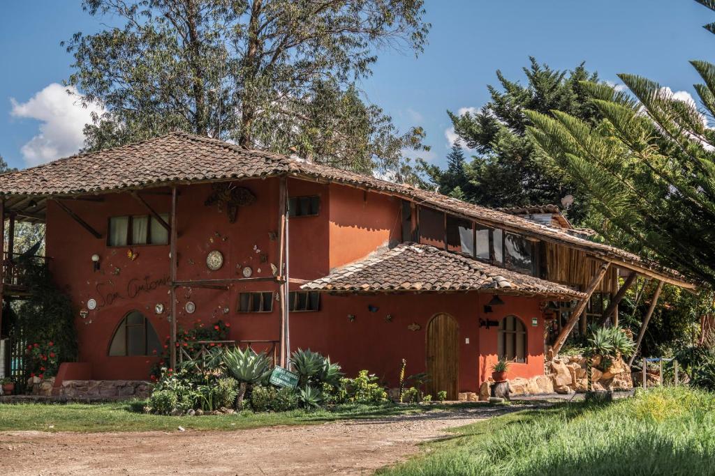 卡哈马卡ART HOUSE Hacienda San Antonio的棕榈树红色房子
