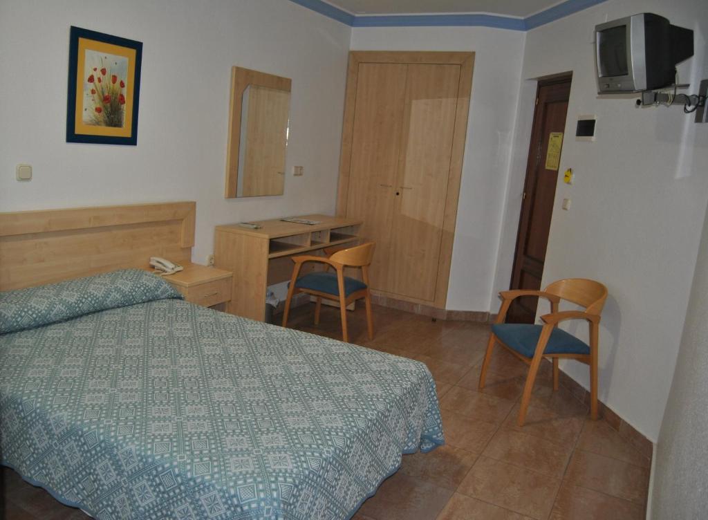 阿尔赫西拉斯布鲁门旅馆的卧室配有一张床和一张桌子及椅子