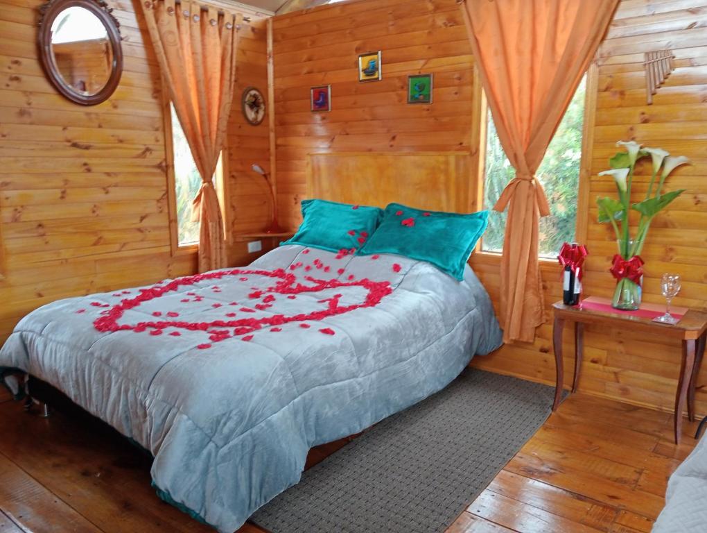 瓜斯卡Cabaña Los Linos的一间卧室,床上有红色的鲜花
