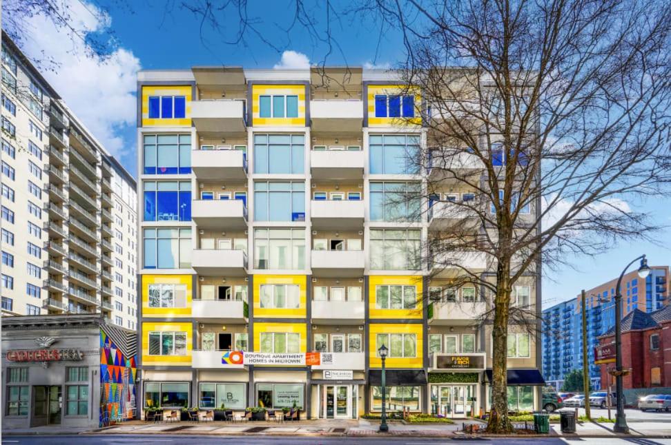 亚特兰大Stylish City Living Apartments with Free Parking in Midtown Atlanta的一座高大的建筑,拥有黄色和蓝色的窗户