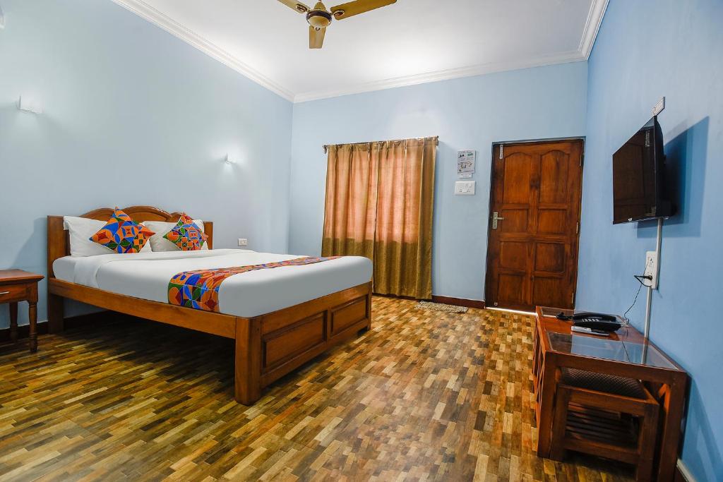瓦加托FabHotel Prime 4D's Coast Resort的一间卧室配有一张床和一台平面电视
