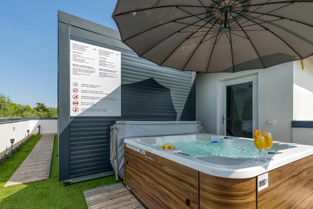 TrebnjeRooftop Home With Whirlpool & Sauna的甲板上的带遮阳伞的热水浴池