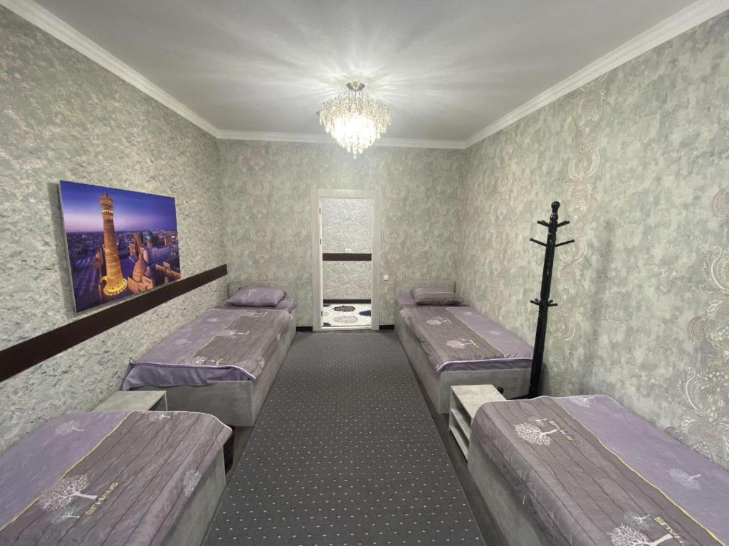 布哈拉Bukhara Hostel的一间医院房间,配有三张床和吊灯